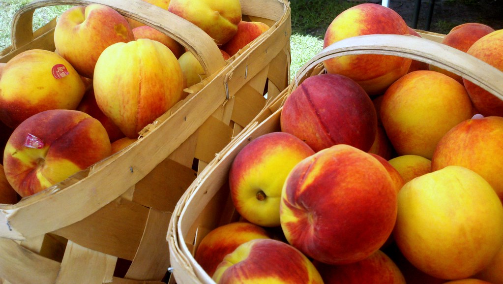 Baskets of fresh peaches at a farmers market